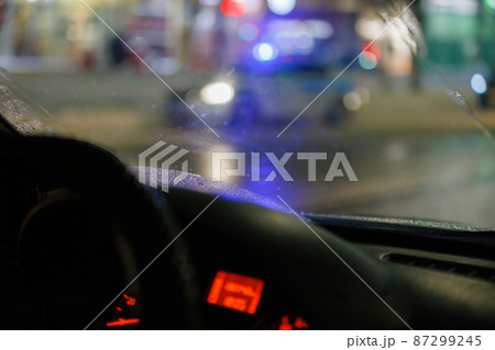 blurry steering wheel and car dashboard with blurred night street background 87299245