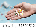 flat lay hand holding assortment pills 87301512