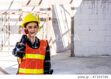 Asian engineer foreman architect worker woman working at building construction site talking with radio Asian engineer foreman architect worker woman working at building construction site talking with radio 87304786