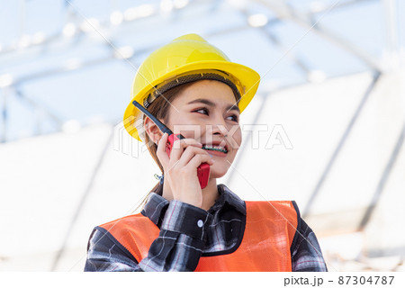 Asian engineer foreman architect worker woman working at building construction site talking with radio 87304787