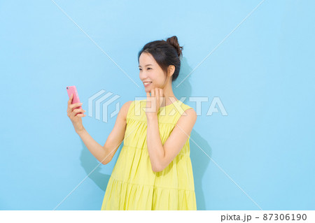 スマホを持つ女性 87306190