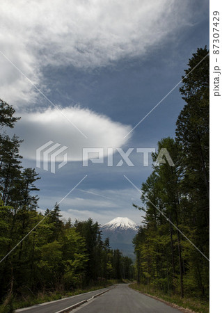 ぽっかりと浮かんだ丸い白い雲の先にある残雪の富士山・忍野村 87307429