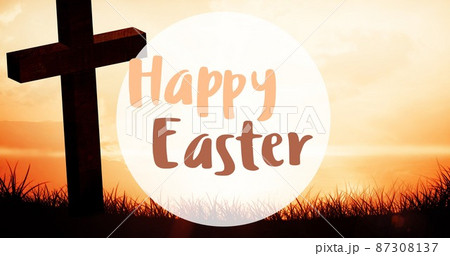 Happy easter symbol text by silhouette cross on grass against sky at sunset 87308137