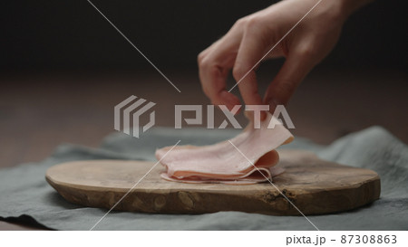 man put prosciutto cotta slices on olive wood board man put prosciutto cotta slices on olive wood board 87308863