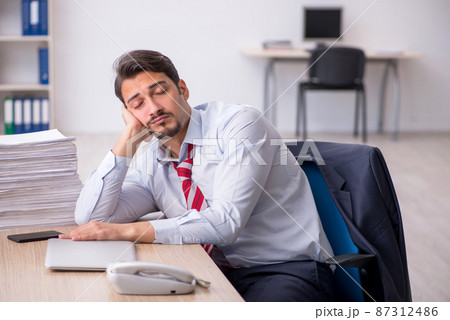 Young male employee sitting at workplace 87312486