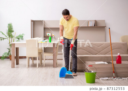 Young male contractor cleaning the house 87312553