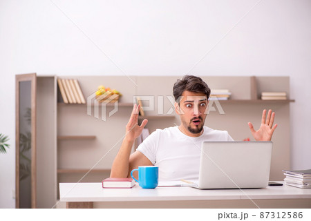Young male employee working from home during pandemic 87312586