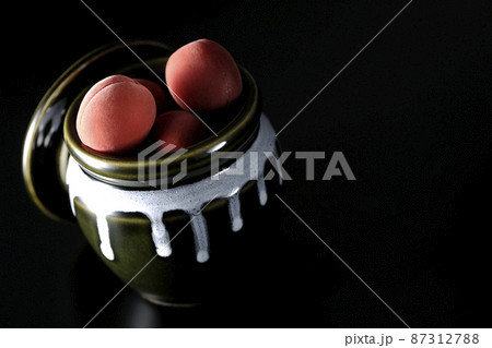 壺に入ってるカリカリ梅を黒背景で撮影 87312788