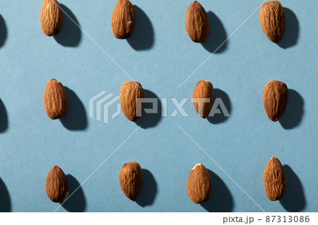 Full frame shot of almonds arranged on blue background with copy space 87313086