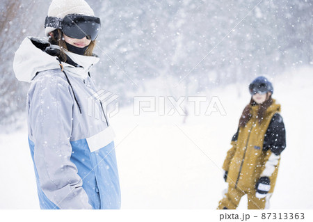 雪の降るスキー場に立つスノボ女子　女子旅 87313363