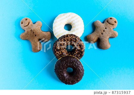 Donut with hazelnuts on blue background, close up Donut with hazelnuts on blue background, close up 87315937