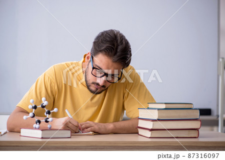 Young male student preparing for exams in the classroom 87316097