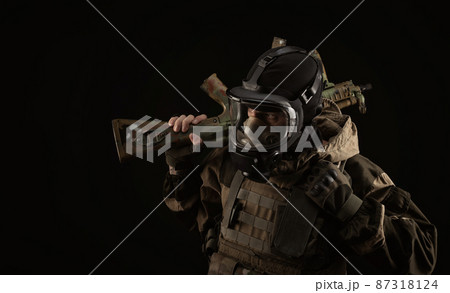 a man in a military uniform and a gas mask holds a weapon with an angry expression of emotion 87318124