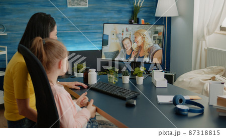 Mother and daughter using video call for conversation with friends 87318815