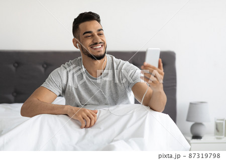 Online Communication. Happy Arab Man Using Smartphone In Bed For Video Call 87319798