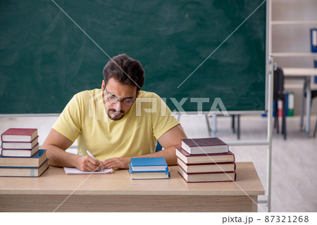 Young male student preparing for exams in the classroom Young male student preparing for exams in the classroom 87321268
