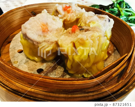 Siu Mai steamed pork prawn mushroom Chinese dumplings in bamboo basket in Yum Cha restaurant 87321651