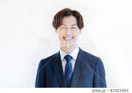 白バックのスーツの若い男性のポートレート　撮影協力：WEEK芝大門(サンフロンティア不動産 87321901