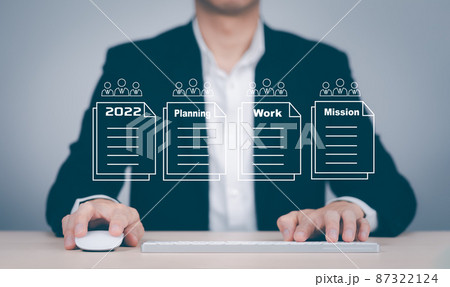 Concept Working and planning for New year 2022, Man hand hold laptop and plans for the new year 2022 in a digital laptop or computer document. Business management, big data,finance technology. 87322124