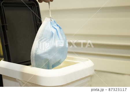 Throwing surgical mask for protection of covid19 virus in the trash Throwing surgical mask for protection of covid19 virus in the trash 87323117