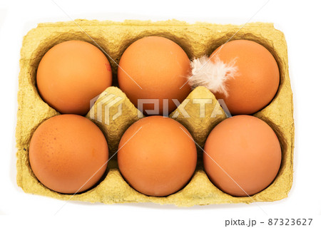 The Netherlands, February 2022. A carton of eggs with feathers on a white background. The Netherlands, February 2022. A carton of eggs with feathers on a white background. 87323627
