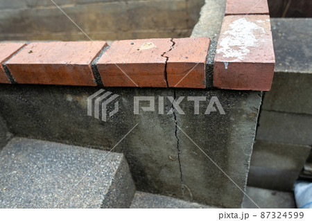 ひび割れの入ったコンクリとレンガ 87324599