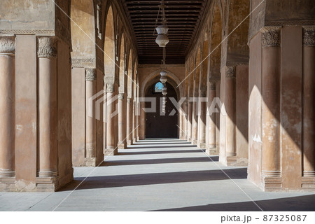 One of the passages surrounding the courtyard of the Mosque of Ahmad Ibn Tulun framed by huge decorated arches, Cairo, Egypt One of the passages surrounding the courtyard of the Mosque of Ahmad Ibn Tulun framed by huge decorated arches, Cairo, Egypt 87325087