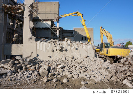 老朽化した公共建造物の解体作業をする重機 老朽化した公共建造物の解体作業をする重機 87325605