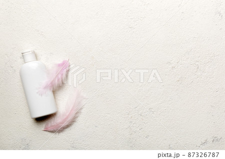 Set of skin care serums on pink pastel background with ostrich feathers. Spa cosmetic product, cream jar, branding mock up, top view with copy space 87326787