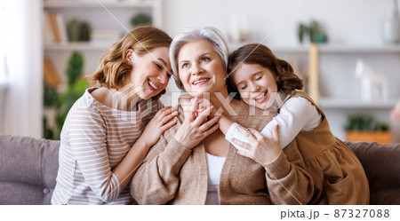 Happy multi generational family: senior woman with daughter and granddaughter on couch Happy multi generational family: senior woman with daughter and granddaughter on couch 87327088