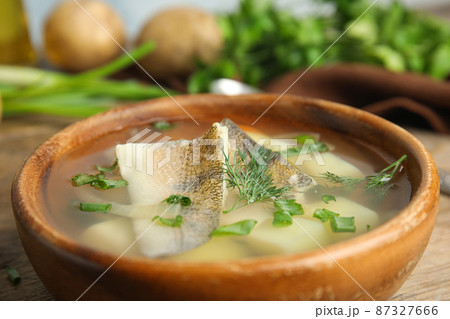 Delicious fish soup in bowl on table, closeup view Delicious fish soup in bowl on table, closeup view 87327666
