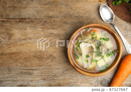 Delicious fish soup served on wooden table, flat lay. Space for text Delicious fish soup served on wooden table, flat lay. Space for text 87327667