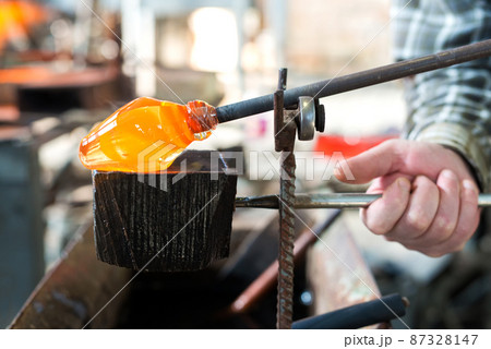 Glass blowing The hands of the craftsman working with molten glass Traditional crafts Glass blowing The hands of the craftsman working with molten glass Traditional crafts 87328147