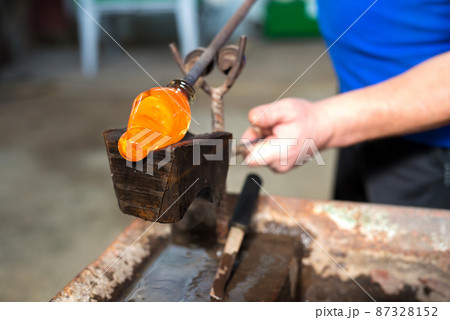 Glass blowing The hands of the craftsman working with molten glass Traditional crafts 87328152
