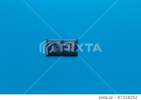 Double black socket power home energy supply electricity on blue wall background Double black socket power home energy supply electricity on blue wall background 87328202