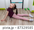A little girl goes in for sports in her room. 87329585