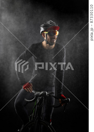 male cyclist with road bicycle on black background 87330110