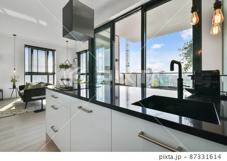 Silver hood in a minimal white kitchen interior with a comfortable wooden countertop. real photo 87331614