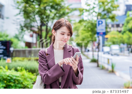 スマホを操作する笑顔のビジネスウーマン 87335497