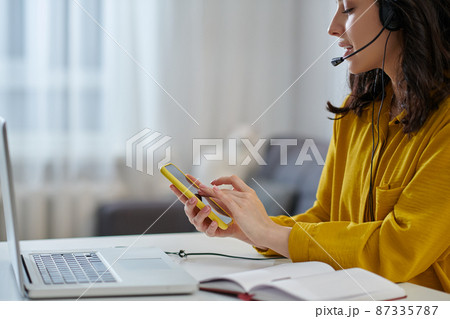 Young woman in a mustard shirt looking busy 87335787
