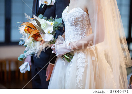 花束を持つ新郎新婦の手元 87340471