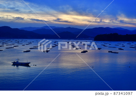夕暮れ時の湾内の養殖筏 87341097