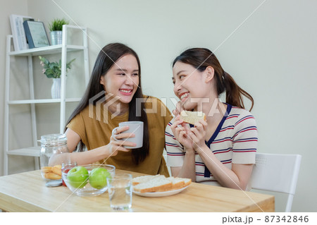 happy asian female couple have breakfast at table kitchen. happy asian female couple have breakfast at table kitchen. 87342846