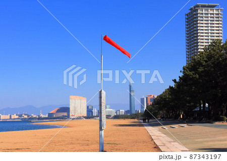 赤い吹き流しとマリナタウン海浜公園から見た百道浜地区の福岡タワーと福岡ドーム 87343197