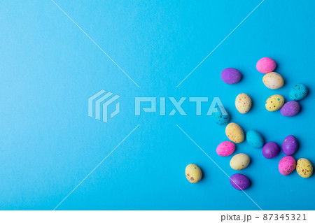 Overhead view colorful eater candies on blue background with copy space 87345321