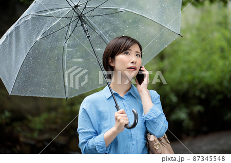女性　スマホ　雨　梅雨 87345548