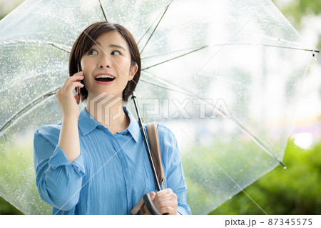 女性　スマホ　雨　梅雨 87345575