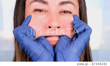 female doctor cosmetologist gives buccal facial massage to herself, teaching and showing Intra oral female doctor cosmetologist gives buccal facial massage to herself, teaching and showing Intra oral 87346282