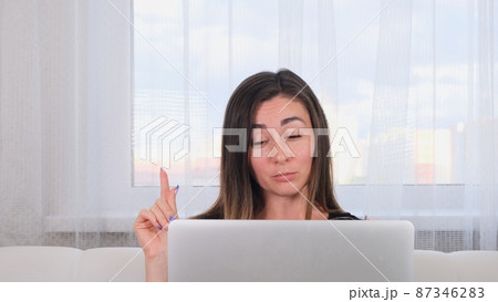 brunette girl blogger talking with friends on social networks on laptop using wireless internet 87346283