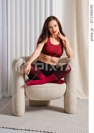 Relaxed woman in colorful pantyhose sitting with her legs tucked under her Relaxed woman in colorful pantyhose sitting with her legs tucked under her 87346690